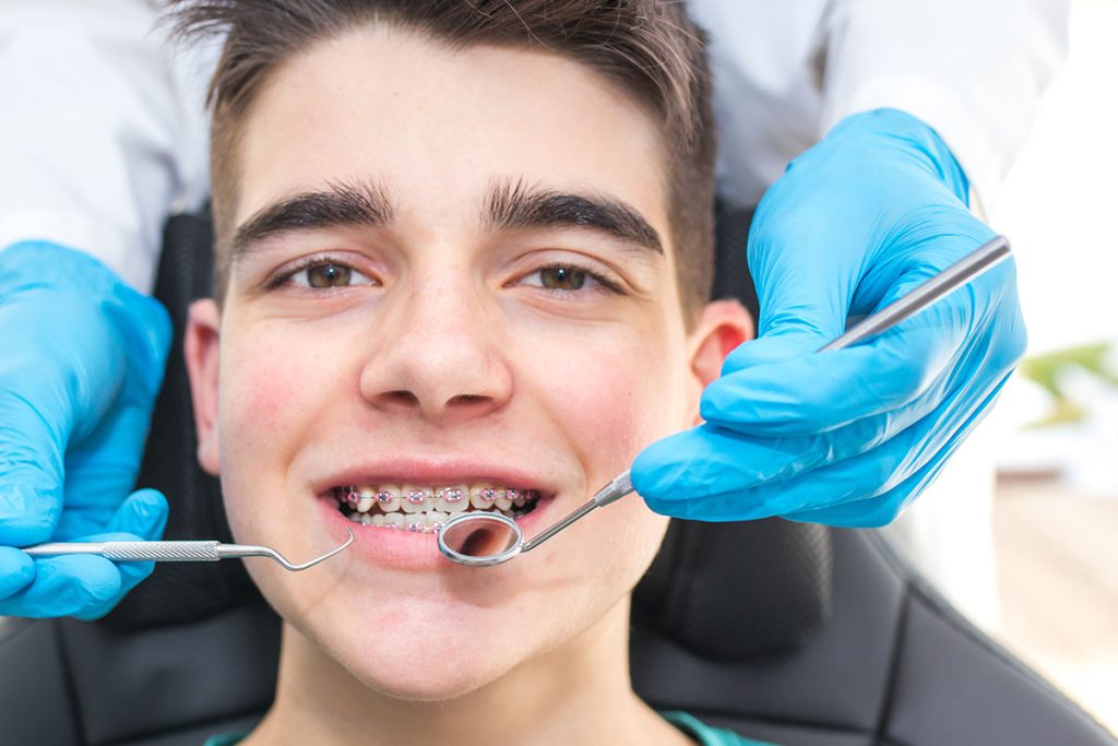 Teenager having braces adjusted, part of orthodontic care by Dr. Boris Kaltchev.