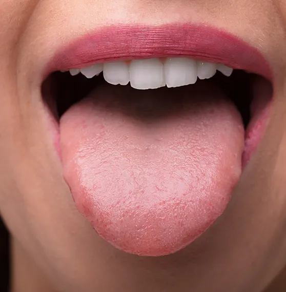 Close-up of a woman's open mouth, showing her tongue and teeth.