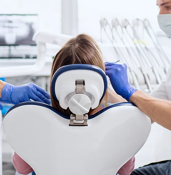 Dentist and assistant performing a dental procedure on a patient in a modern dental clinic.