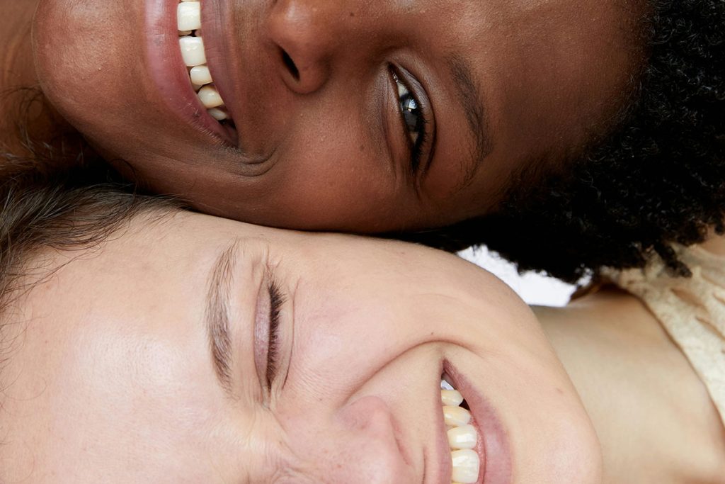 Two people smiling cheek to cheek next to each other.